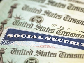 Nesta ilustração fotográfica, um cartão do Seguro Social fica ao lado de cheques do Tesouro dos EUA em 14 de outubro de 2021 em Washington.  Kevin Dietsch/Getty Images)