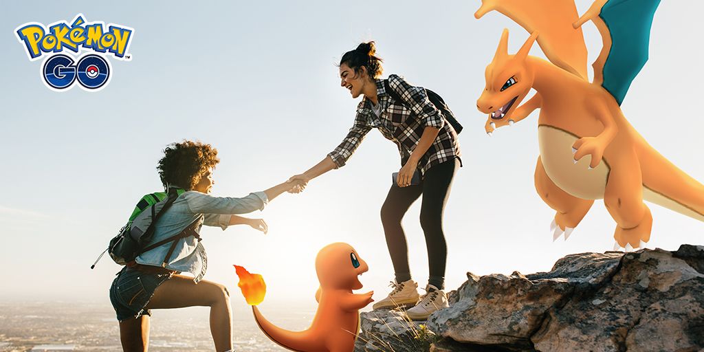 One person helping another climbing up a cliff, one with a Charmander, one with a Charizard