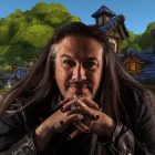 John Romero sitting in front of a WoW backdrop