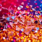 An extreme close-up photograph of shattered glass and glittering sequins in vibrant red, blue, and gold hues, creating an abstract, high-contrast composition that evokes the excitement and glamour of the trading card game genre